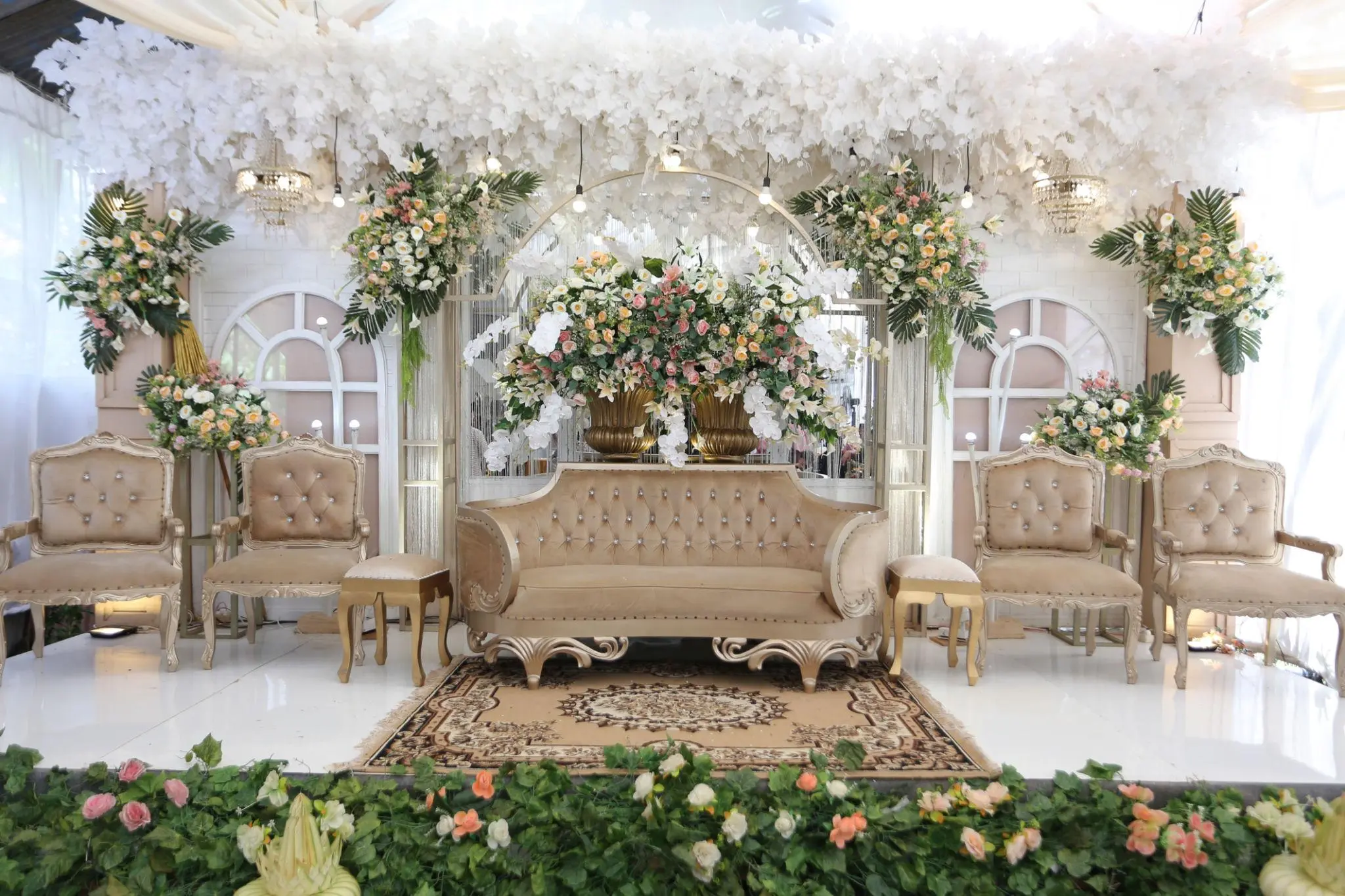 Dekorasi wedding indoor dengan bunga dan backdrop pelaminan